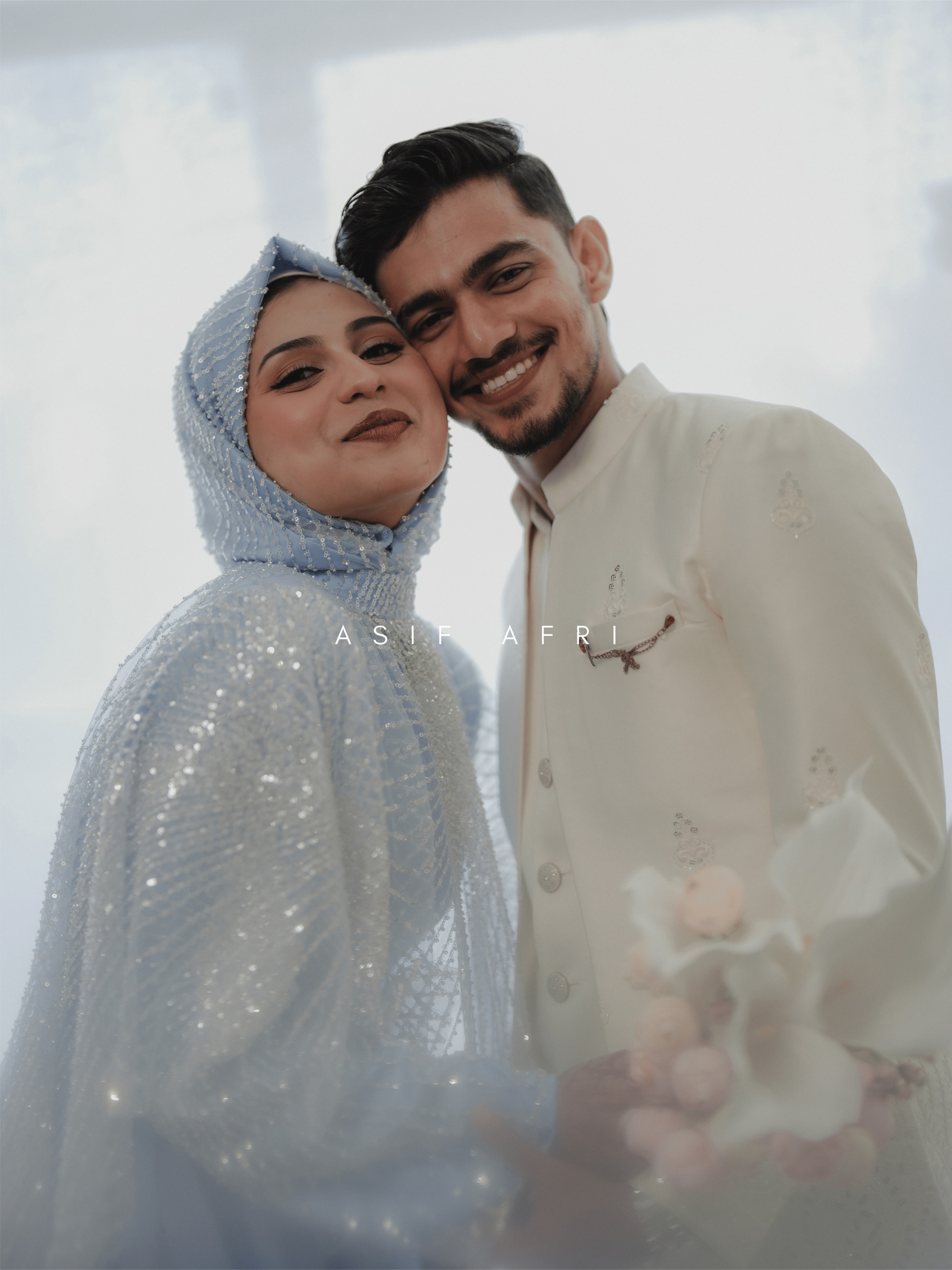Newlyweds smiling together in ivory wedding attire