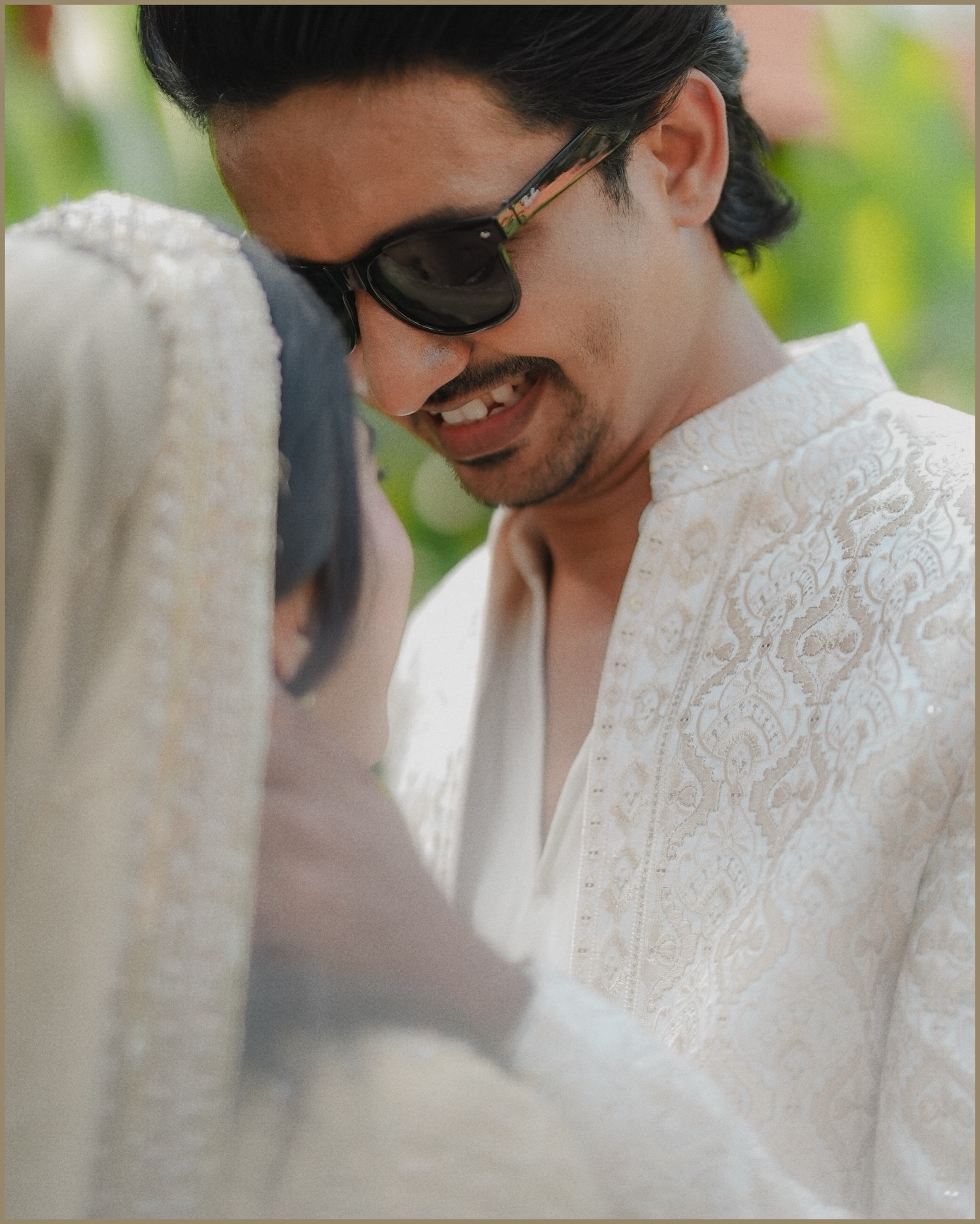 Smiling groom in embroidered ivory wedding attire